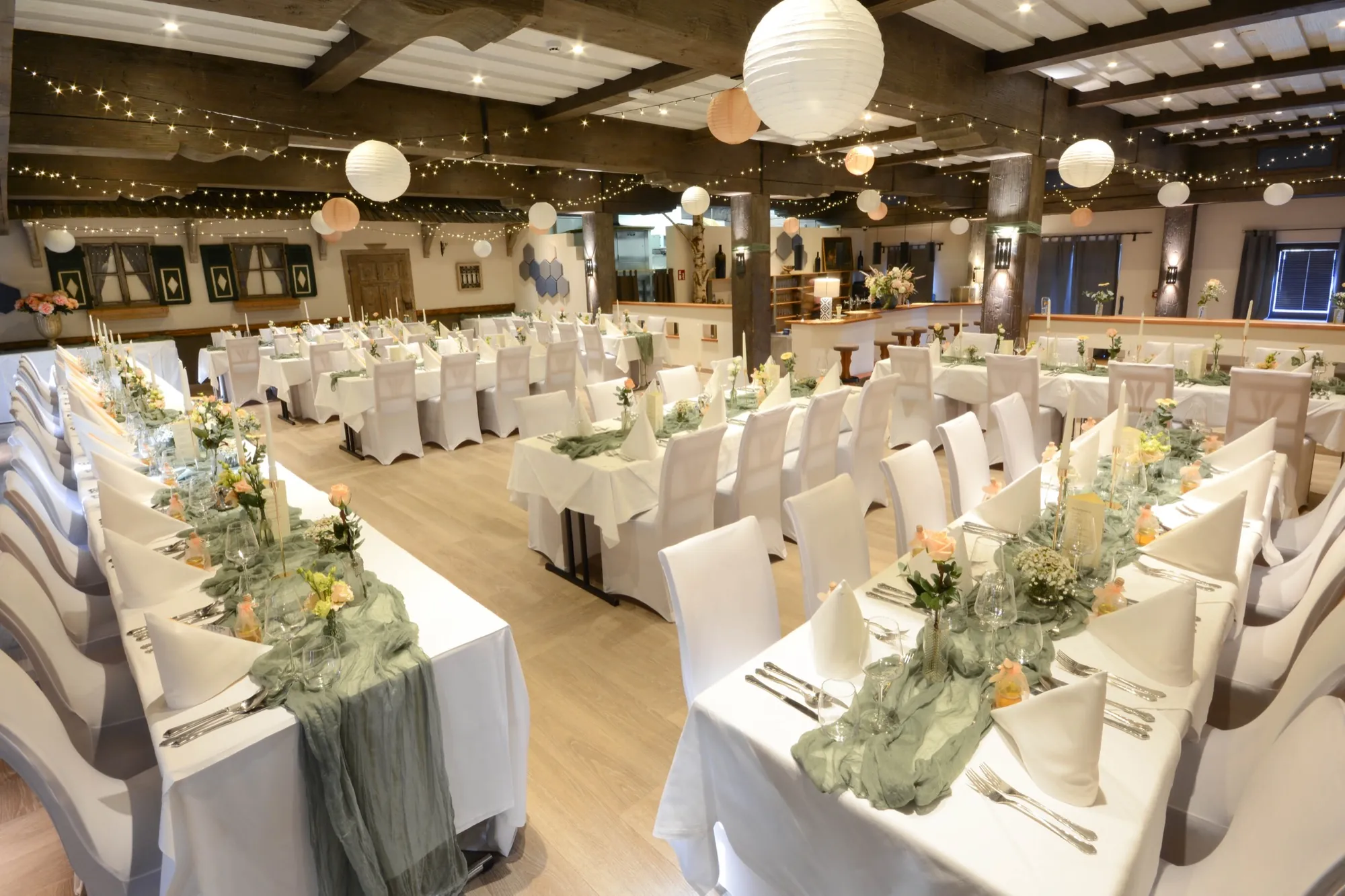 Kaisersaal im Hotel Kaiserhof Anif bei Salzburg, für eine Hochzeit mit langen Tafeln, Lampions und Lichterketten eingedeckt