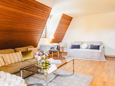 comfortables Sofa Ausziehcouch und Schreibtisch im Wohnzimmer der Ferienwohnung im Kaiserhof Anif