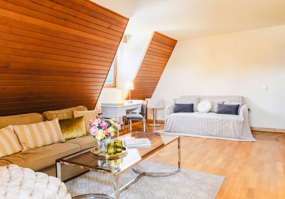 comfortables Sofa Ausziehcouch und Schreibtisch im Wohnzimmer der Ferienwohnung im Kaiserhof Anif