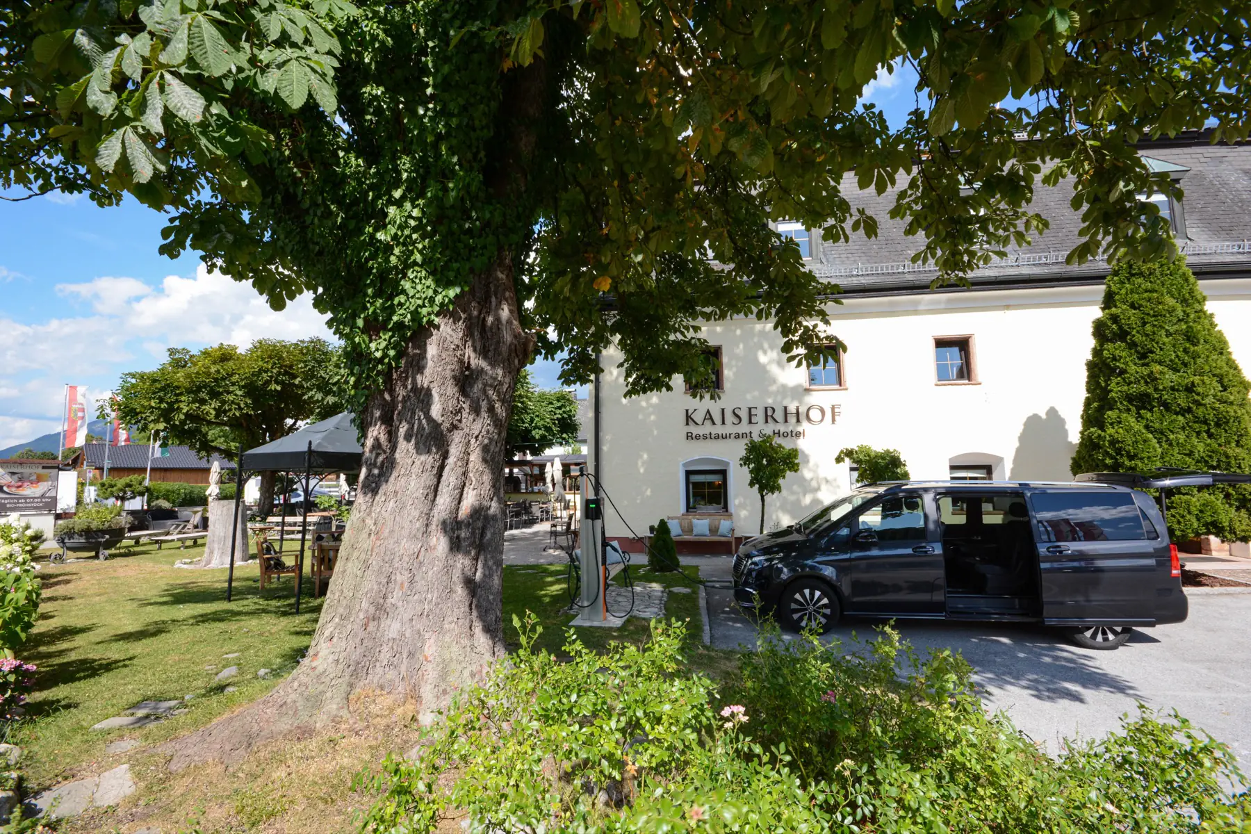 Hotel Kaiserhof Anif beneath the old chestnut tree, vehicle at the charging station