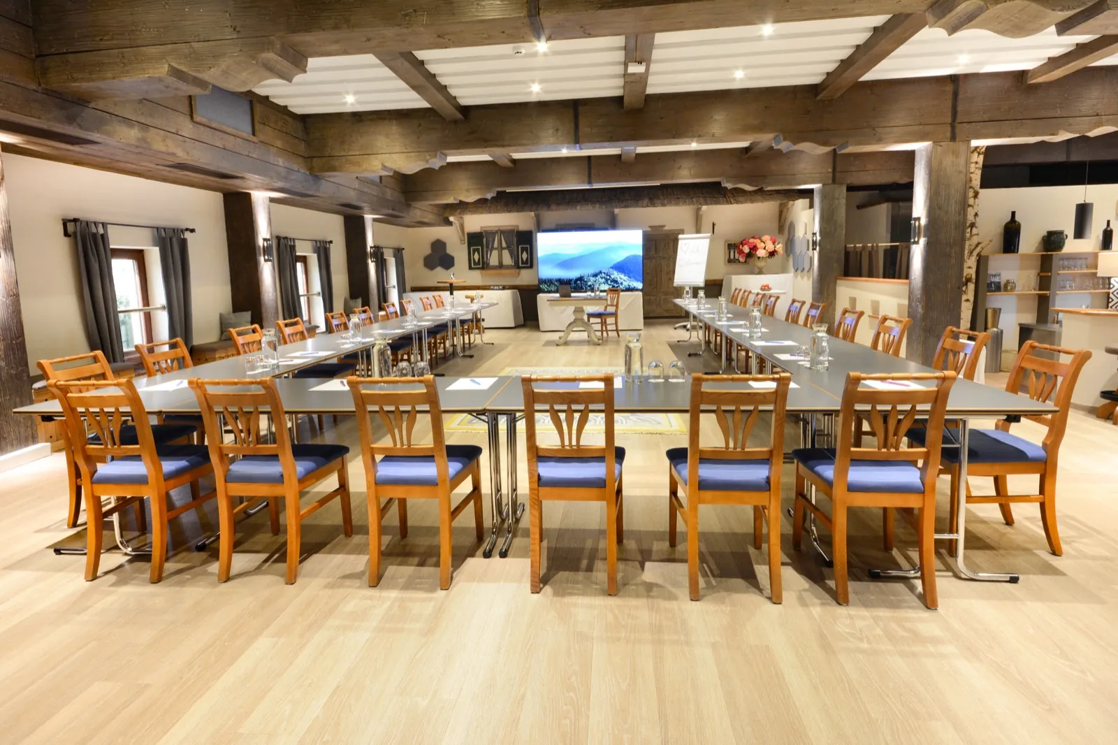 Seminar I / Kaisersaal im Kaiserhof Anif – großer Saal mit Holzbalkendecke, U-Form-Bestuhlung und Großbildschirm