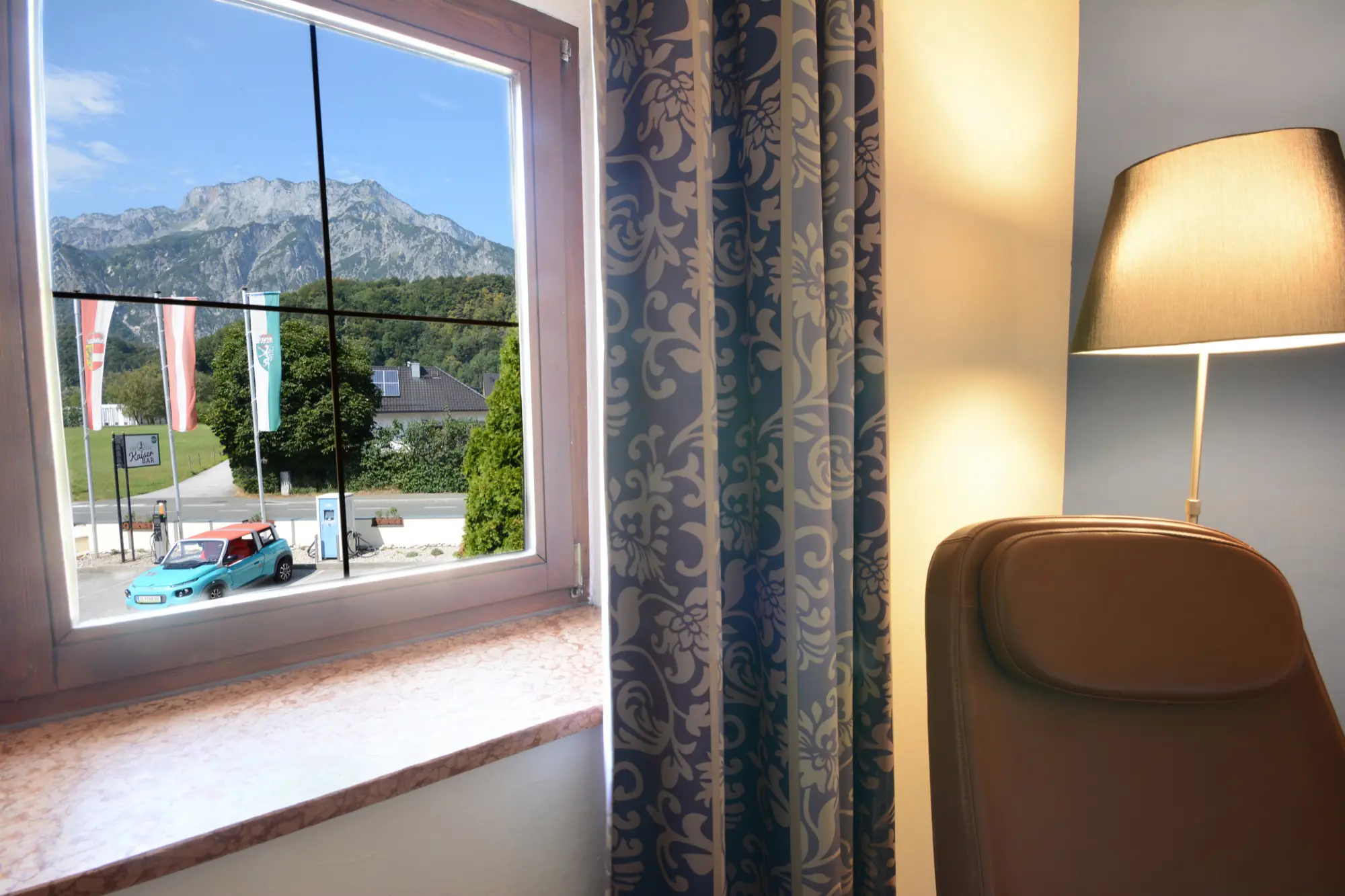 Blick aus einem Superior-Zimmer im Hotel Kaiserhof Anif auf den Untersberg und die E-Ladestationen