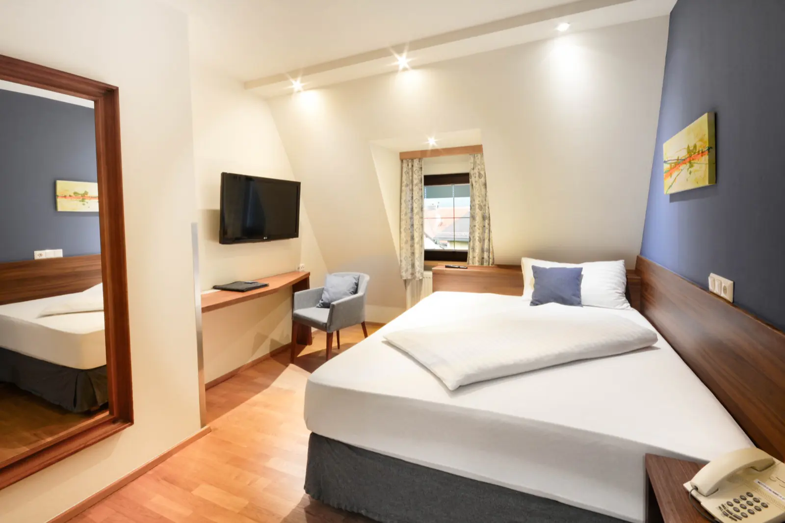 Comfort Piccolini im Hotel Kaiserhof Anif – kompaktes Zimmer mit Schreibtisch, Flatscreen und Dachfenster